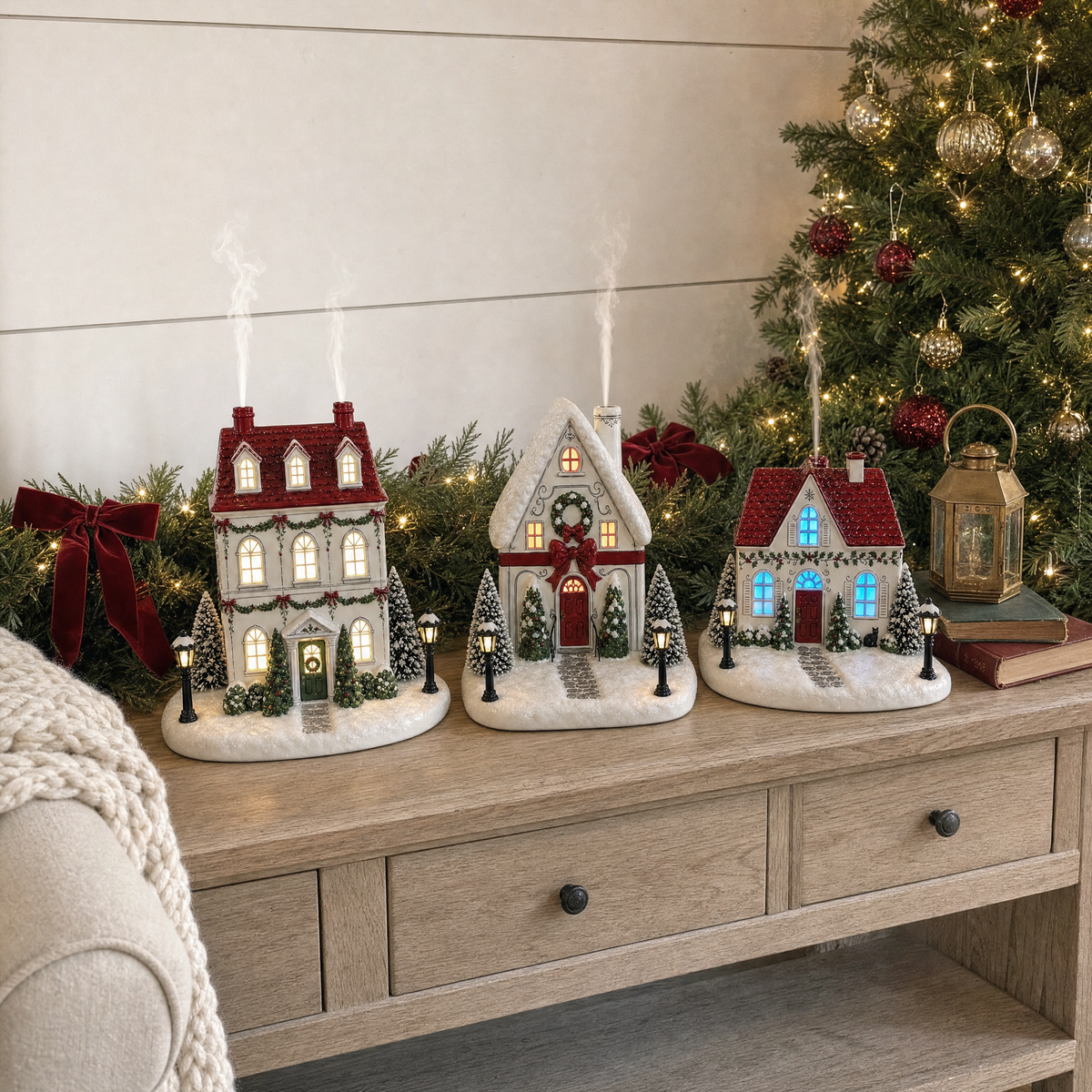 Three illuminated Christmas house diffusers displayed together